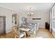Dining room with chandelier lighting, hardwood floors, and an arched doorway with views of the kitchen at 2920 Claremont Rd, Raleigh, NC 27608