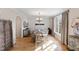 Bright dining room featuring a chandelier, hardwood floors, and large windows with decorative window treatments at 2920 Claremont Rd, Raleigh, NC 27608