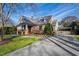 Beautifully landscaped two-story home with a stone facade, driveway, and charming backyard fence and arbor at 2920 Claremont Rd, Raleigh, NC 27608
