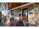 Close-up of the front door with stone facade, sconces, and stained wood door with glass panel at 2920 Claremont Rd, Raleigh, NC 27608