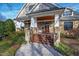 Inviting front porch with wood ceiling, stone accents, and stained wood steps leading to the entrance at 2920 Claremont Rd, Raleigh, NC 27608