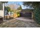 A detached two-car garage with a stone facade and a pergola covered entrance sits in a gravel driveway at 2920 Claremont Rd, Raleigh, NC 27608