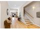 Spacious hallway with hardwood floors, decorative bench, and staircase with natural light at 2920 Claremont Rd, Raleigh, NC 27608