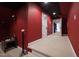 View down the hallway to the media room featuring red walls, black ceiling, and carpeted floors at 2920 Claremont Rd, Raleigh, NC 27608