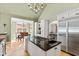Sun-drenched kitchen island with cooktop and stainless appliances, leading to the breakfast nook at 2920 Claremont Rd, Raleigh, NC 27608