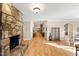 Spacious living room with a stone fireplace, hardwood floors, and a long hallway with decorative accents at 2920 Claremont Rd, Raleigh, NC 27608