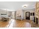 Open-concept living and dining area with a stone fireplace, hardwood floors, and natural light at 2920 Claremont Rd, Raleigh, NC 27608