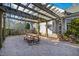 A wooden pergola with a table and bench sits on gravel between the house and a fenced yard at 2920 Claremont Rd, Raleigh, NC 27608