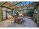 A wooden pergola with a table and benches provides an outdoor seating area in a gravel-covered backyard at 2920 Claremont Rd, Raleigh, NC 27608