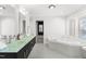 Bathroom featuring double sinks, a modern bathtub with marble surround, and neutral paint at 3021 Allenby Dr, Raleigh, NC 27604
