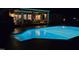 An inviting swimming pool is lit up at night showing access from the home's covered patio at 3021 Allenby Dr, Raleigh, NC 27604