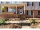 Brick home with inviting front porch, black shutters, and manicured landscaping leading to the front door at 330 Wesley Dr, Chapel Hill, NC 27516