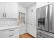 Updated kitchen with stainless steel refrigerator, pantry, white cabinetry, and backyard access at 330 Wesley Dr, Chapel Hill, NC 27516