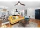 Open-concept living area with hardwood floors, a bright yellow sofa, and a view into the modern kitchen at 330 Wesley Dr, Chapel Hill, NC 27516