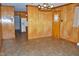 Spacious dining area with wood-paneled walls, vintage lighting, and tile flooring at 3359 Huffines Dr, Burlington, NC 27217