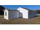 Side exterior view of white house and storage shed, with dark grey trim and blue sky at 3359 Huffines Dr, Burlington, NC 27217