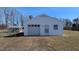 A detached one-car garage with a white door and white siding is beside a greenhouse at 3359 Huffines Dr, Burlington, NC 27217