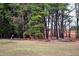 Grass yard surrounded by trees and woods with area for seating at 3359 Huffines Dr, Burlington, NC 27217