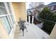 A balcony with iron table and chairs overlooks greenery and nearby homes at 3937 Bentley Brook Dr, Raleigh, NC 27612