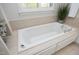 Close up of bathtub featuring tile surround and controls at 3937 Bentley Brook Dr, Raleigh, NC 27612