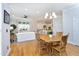 A well-lit dining room with a wooden table and chairs leads to an open kitchen and living area at 3937 Bentley Brook Dr, Raleigh, NC 27612