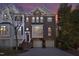 Charming brick townhome featuring a two-car garage and meticulously maintained landscaping at dusk at 3937 Bentley Brook Dr, Raleigh, NC 27612