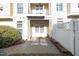 Exterior view of a cozy outdoor patio space with brick pavers, enclosed by a white fence and mature landscaping at 3937 Bentley Brook Dr, Raleigh, NC 27612