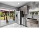 A modern kitchen featuring stainless steel appliances, subway tile backsplash, and sliding doors to the backyard at 4002 Rothfield Ln, Raleigh, NC 27616