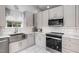 Well-lit kitchen featuring stainless steel appliances, gray cabinets, and marble countertops at 4002 Rothfield Ln, Raleigh, NC 27616