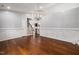 Elegant living room with gleaming hardwood floors, wainscoting, and a crystal chandelier at 4002 Rothfield Ln, Raleigh, NC 27616