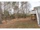 Backyard with many trees features a raised deck and stairs, partial privacy fence, and room to play at 401 Acorn Falls Ct, Holly Springs, NC 27540