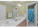 Bathroom with double vanity, large mirror and separate toilet with a bright shower curtain with flower design at 401 Acorn Falls Ct, Holly Springs, NC 27540