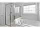 Bathroom features a glass door shower, soaking tub, tiled walls and natural light at 401 Acorn Falls Ct, Holly Springs, NC 27540