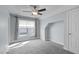 Bedroom boasts natural light, a ceiling fan, and neutral walls and carpet at 401 Acorn Falls Ct, Holly Springs, NC 27540
