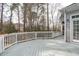 Backyard deck features white railings, views of tall trees, and a door into the home at 401 Acorn Falls Ct, Holly Springs, NC 27540