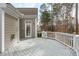 Backyard deck features white railings and a door leading inside, surrounded by trees at 401 Acorn Falls Ct, Holly Springs, NC 27540