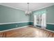 Bright dining room featuring hardwood floors, fresh blue paint, and natural light from a large window at 401 Acorn Falls Ct, Holly Springs, NC 27540