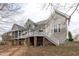 Back exterior of home with many decks, wood and vinyl siding, and multi-level backyard at 401 Acorn Falls Ct, Holly Springs, NC 27540