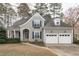 Charming home featuring a manicured lawn, attached two car garage, and inviting entryway at 401 Acorn Falls Ct, Holly Springs, NC 27540