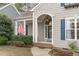Charming home featuring a welcoming front entrance with blue shutters and American flag at 401 Acorn Falls Ct, Holly Springs, NC 27540