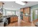 Open-concept kitchen featuring hardwood flooring, wood cabinetry, stainless steel appliances and granite counters at 401 Acorn Falls Ct, Holly Springs, NC 27540