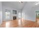 Bright living room featuring wood flooring, a fireplace and large window that provides lots of natural light at 401 Acorn Falls Ct, Holly Springs, NC 27540