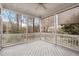 Screened porch features wood floor, wood railing, and shade screens looking out on a wooded backyard at 401 Acorn Falls Ct, Holly Springs, NC 27540