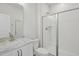 Modern bathroom featuring a glass-enclosed shower, white tile, and a sleek vanity at 4724 Cypress Tree Ln, Raleigh, NC 27612