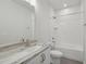 Well-lit bathroom with a shower-tub combo, modern fixtures, and vanity with marbled top at 4724 Cypress Tree Ln, Raleigh, NC 27612