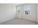 Cozy bedroom with soft carpet and two large windows offering serene neighborhood views at 4724 Cypress Tree Ln, Raleigh, NC 27612