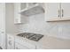 Modern kitchen with a gas cooktop, stone backsplash, and white cabinetry at 4724 Cypress Tree Ln, Raleigh, NC 27612