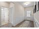 Inviting entry way with wainscoting detail and wood-look floors leading to a bathroom and front door at 4888 Pioneer Dr, Sanford, NC 27330
