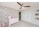 Charming bedroom with pink floral wallpaper, ceiling fan, and white double door closet at 512 Oak Holly Ln, Zebulon, NC 27597