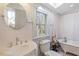 Bright bathroom with a combination tub, vanity, toilet, and lots of natural light from the large window at 516 N Bloodworth St, Raleigh, NC 27604